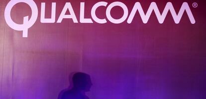 Un hombre pasea junto al logo de Qualcomm.