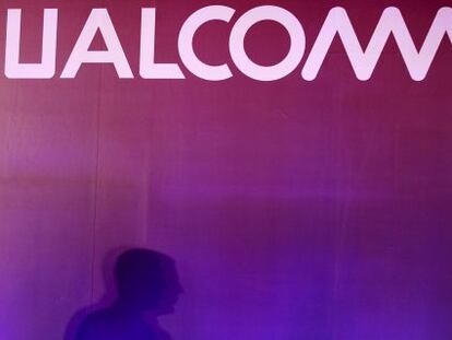 Un hombre pasea junto al logo de Qualcomm.