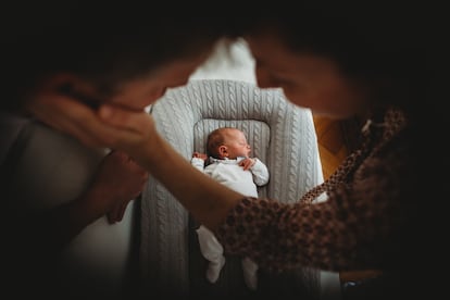 Una pareja junto a su bebé recién nacido.