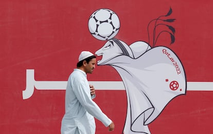 Un hombre pasa junto a un cartel de La'eeb, la mascota de Qatar 2022, en Doha.