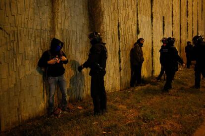 Agents dels Mossos identifiquen manifestants durant el bloqueig d'una carretera a Barcelona.