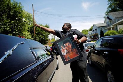 Un hombre lanza una rosa sobre el coche fúnebre que lleva los restos de Muhammad Ali, en Louisville (Estados Unidos).