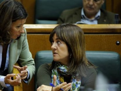 La parlamentaria del PP Laura Garrido habla con Idoia Mendia, en su escaño durante el pleno.