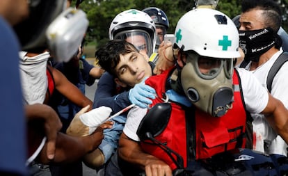 David José Vallenilla, quien fue lesionado fatalmente, es ayudado por miembros voluntarios de un equipo de atención primaria fuera de una base de la fuerza aérea durante enfrentamientos con fuerzas de seguridad antidisturbios en una manifestación contra el gobierno del presidente venezolano Nicolás Maduro en Caracas, Venezuela.