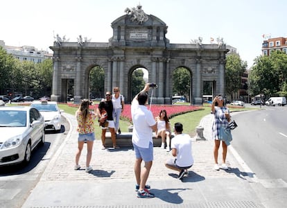 Varios turistas se fotografían ante Puerta de Alcalá, en el centro de Madrid.