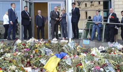 La titular de Exteriores australiana, junto a su homólogo holandés, señala a un tributo floral a las víctimas del vuelo MH17 en la embajada holandesa en Kiev (Ucrania)