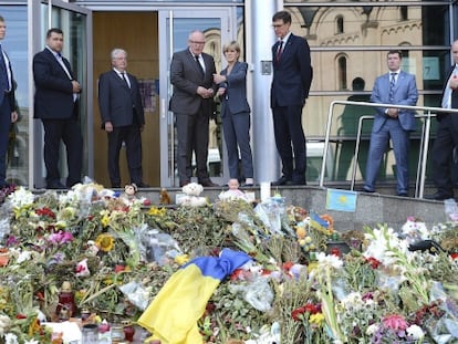La titular de Exteriores australiana, junto a su homólogo holandés, señala a un tributo floral a las víctimas del vuelo MH17 en la embajada holandesa en Kiev (Ucrania)
