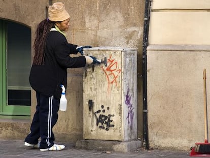 Una trabajadora limpia la calle contratada por Barcelona Activa dentro de uno de los programas sociales