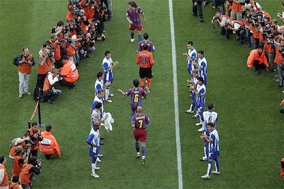 Los jugadores del Espanyol hacen pasillo a los del Bar?a en homenaje al campen antes del inicio del partido.