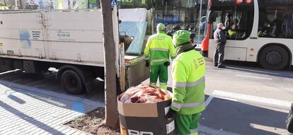 Operarios se llevan mantas de personas que viven en la calle. 