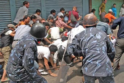 Policías nepaleses arremeten contra un grupo de opositores, entre los que se encuentran varios turistas, durante una carga con bastones en Thamel, una zona turistica de Katmandú.