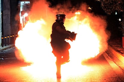 Un cóctel molotov explota tras un policía antidisturbios en Atenas.