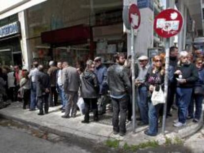 Varias personas hacen cola delante de una farmacia abierta en la zona Pagrati, en Atenas (Grecia) hoy, viernes 28 de marzo de 2014.