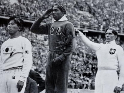 Jesse Owens no pódio olímpico depois de sua vitória no salto em distância nos Jogos Olímpicos de Berlim 1936.