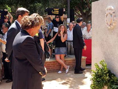 La alcaldesa Rita Barberá ayer frente al monolito, y al fondo algunos de los familiares de víctimas y heridos en el accidente.