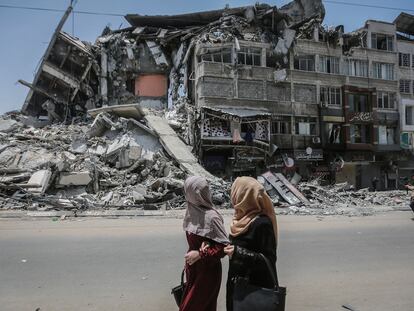 Varias personas pasan frente a un edificio destruido por los bombardeos en Gaza.