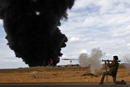 Un rebelde dispara con un lanzagranadas frente a una instalación de gas en la carretera que une Ras Lanuf y Bin Yauad.
