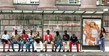 Un grupo de inmigrantes descansaba ayer en una parada de autobús, ante la oficina municipal de inmigración.