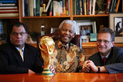 Nelson Mandela posa con el trofeo junto a los representantes de la FIFA.