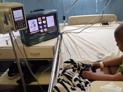 Un niño internado en una sala de oncología juega un videojuego en una consola de La Guardia.
