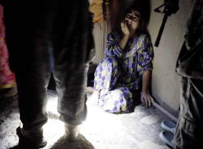 Una mujer llora mientras soldados estadounidenses detienen a sus familiares varones, ayer en Bagdad.
