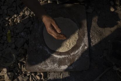 Detalle de la mano de una mujer preparando el tradicional pan sirio.
