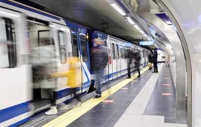 Varias personas esperan la llegada de un vagón del Metro de Madrid.