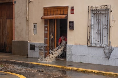 Un hombre achica agua, en Llombai, Valencia, este martes.