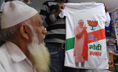 Un comerciante muestra una camiseta con la figura del primer ministro indio Narendra Modi en una tienda de Nueva Delhi el pasado 13 de marzo.