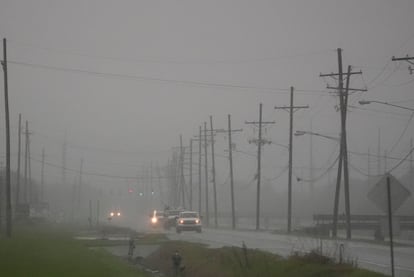 Automovilistas conducen a través de bandas de lluvia a lo largo de Peter Rd., a las afueras de Nueva Orleans, en Harvey (Luisiana), este martes.