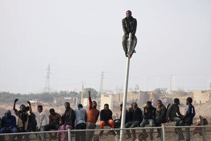 Algunos inmigrantes en la primera de las dos vallas, la que da a Marruecos; otros en el espacio comprendido entre las dos verjas e, incluso, uno est&aacute; subido a una farola situada junto al per&iacute;metro.