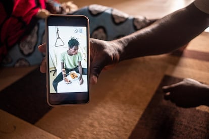 Ibrahim Sarr, a resident of Fas Boye, shows a photo of his son, who is hospitalized in Cape Town after surviving the trip.