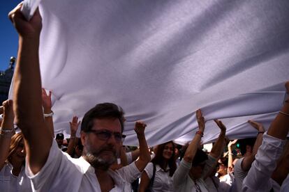 Manifestantes sujetan una enorme bandera blanca en la plaza de Cibeles de Madrid.