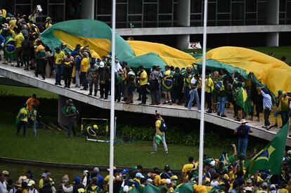 Cientos de manifestantes avanzan por la rampa del edificio del Congreso, en Brasilia.  
