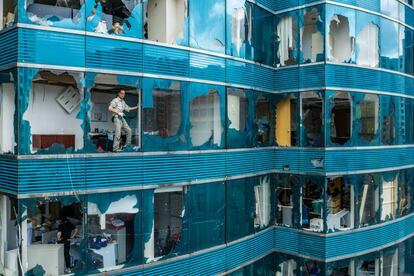 Un trabajador retira cristales de un edificio tras el paso del tifón Mangkhut en Hong Kong (China), el 17 de septiembre de 2018.