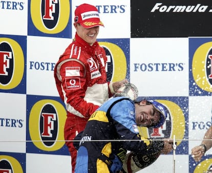 El alemán moja con champán a Alonso mientras celebra su triunfo en el podio de Silverstone (Gran Bretaña) el 11 de junio de 2006.