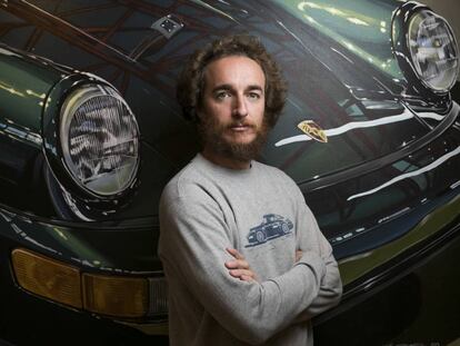 Manu Campa, pintor realista, fotografiado delante de una de sus pinturas de un Porsche.