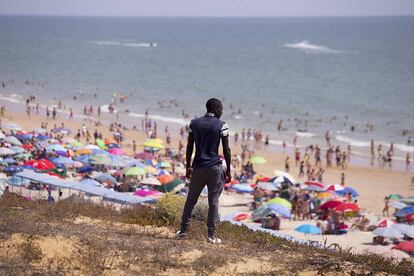 Ndiaya, un inmigrante senegalés, se asoma desde una atalaya a un playa del sur de Europa para saber mejor cómo ganarse la vida.