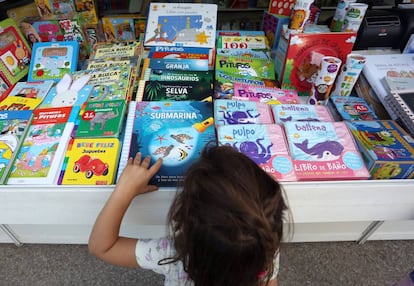 Feria del Libro de Madrid. Una niña mira libros en una caseta.