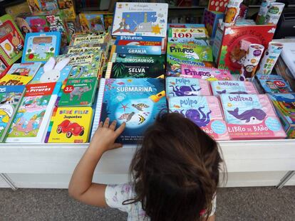 Feria del Libro de Madrid. Una niña mira libros en una caseta.