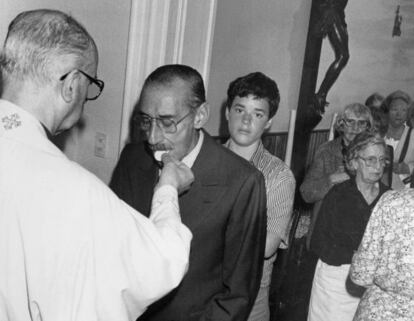 El dictador Jorge Videla recibe la comuni&oacute;n de un sacerdote local.