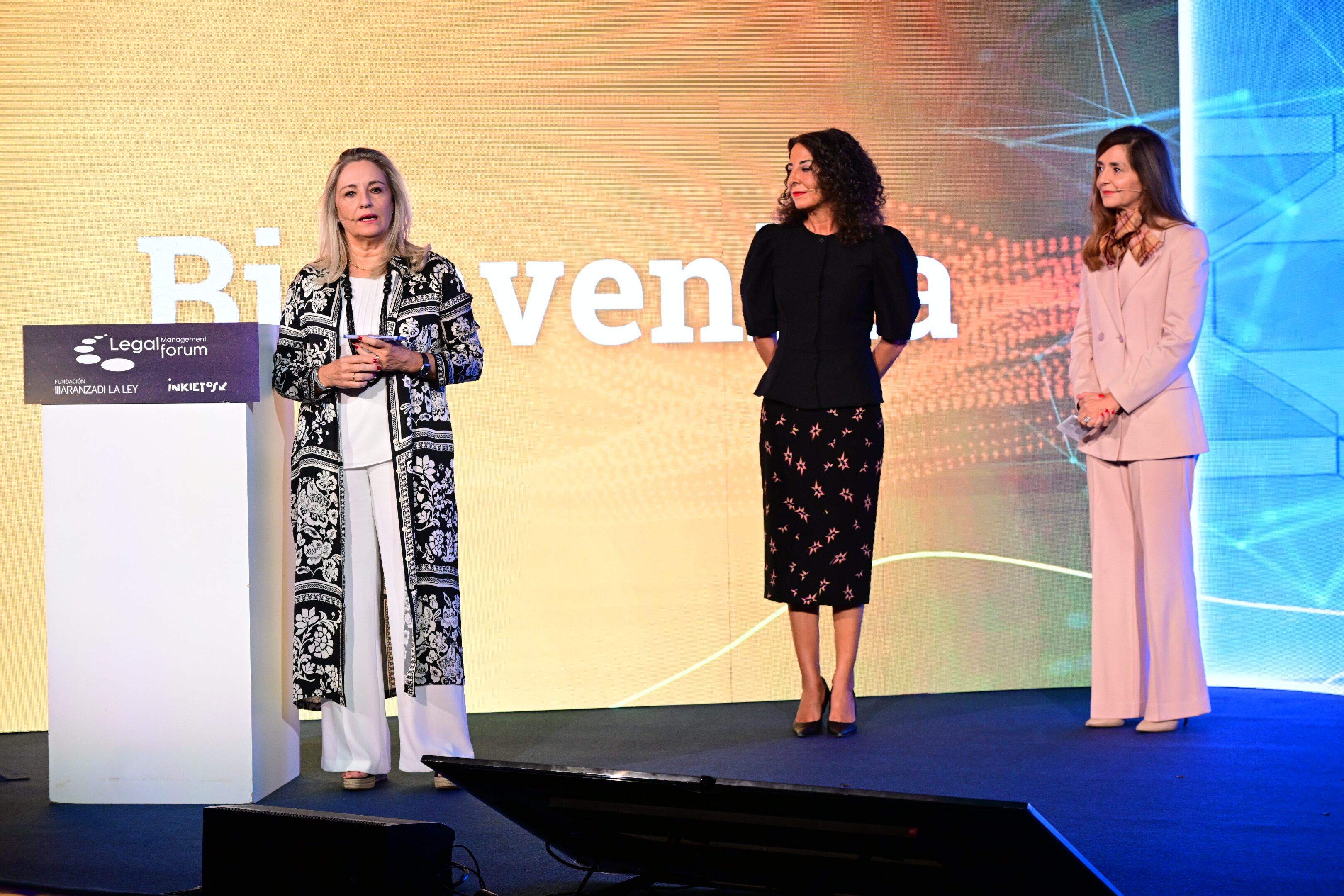 Bienvenida oficial a la sesión plenaria del Legal Management Forum 2025. En la foto, de izq. a dcha. Cristina Sancho, presidenta de la Fundación Aranzadi LA LEY; Mercedes Carmona, presidenta de Inkietos, el think tank coorganizador del evento; y Alicia Muñoz Lombardía, vicesecretaria del Consejo de Santander España, principal patrocinador, y directora de la Asesoría de Banca comercial, gobernanza y regulación.