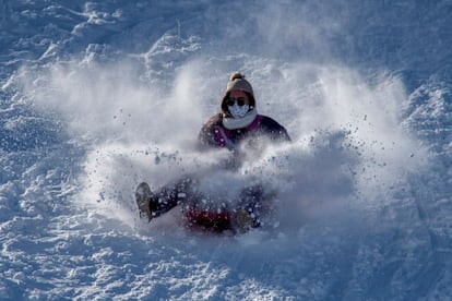 Una mujer se desliza por la nieve en un trineo, este sábado en Cabeza de Manzaneda (Ourense).