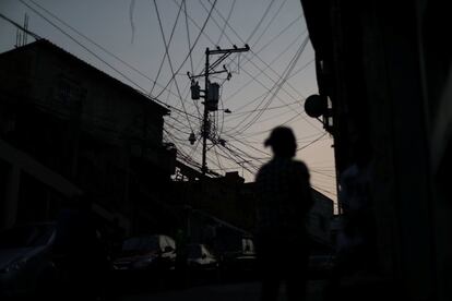 Una red de cableado eléctrico es fotografiada a contraluz en un barrio de Caracas (Venezuela) durante el tercer día de apagón en el país petrolero, el 27 de marzo de 2019. Los apagones son habituales en Venezuela desde hace una década y expertos atribuyen la situación a la falta de inversión en infraestructura y a la corrupción. La noche del miércoles, el líder chavista Nicolás Maduro asomó un posible racionamiento de electricidad: "Vamos a pasar días donde vamos a tener que ir a administración de carga organizada para estabilizar el servicio".