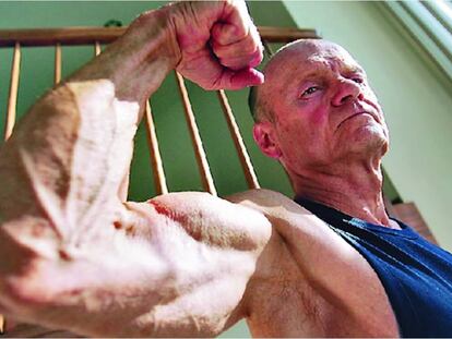 El culturista Clarence Bass muestra con orgullo las dimensiones de su bíceps.