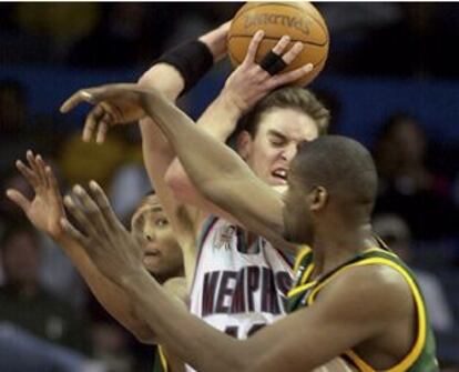 Gasol lucha un balón contra los jugadores de los Supersonics Rashard Lewis y Jerome James