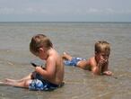Dos niños juegan en la orilla del mar.