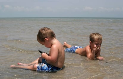 Dos niños juegan en la orilla del mar.