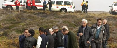 Amigos y familiares de los pescadores desaparecidos observan los trabajos de los equipos de rescate.