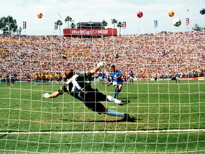 Italian forward Roberto Baggio kicks the ball but misses the goal in a penalty kick while the Brazilian goalkeeper Taffarel dives for the ball during the 1994 World Cup final Brazil against Italy in Pasadena, USA, 17 July 1994. The Brazilian team won the game 3-2 against Italy on penalties and won the world champion title for the fourth time. (Photo by /picture alliance via Getty Images)